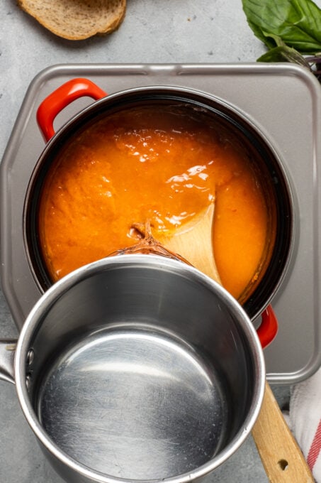 把水倒进锅新鲜的番茄汤。