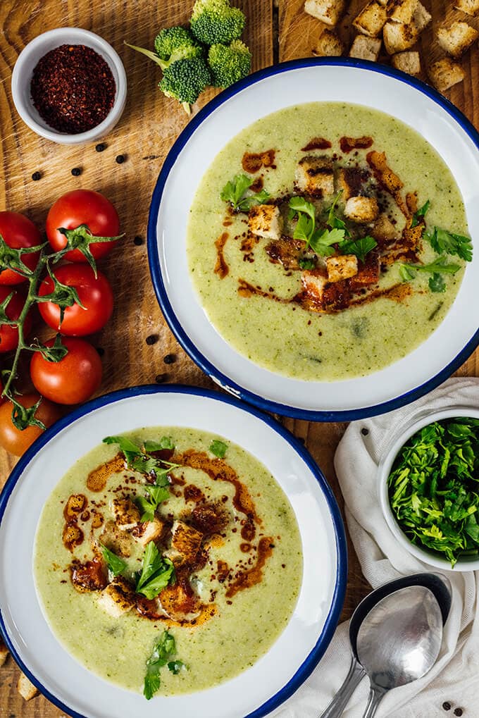 Cream of Broccoli Soup is super creamy without cream. This is such a heart-warming and tasty soup. Ready in less than 30 minutes. Perfect for busy winter days! 奶油花椰菜汤装在两个白色的碗里,放在木板上。