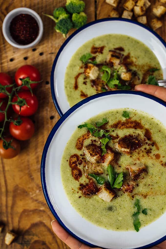 Cream of Broccoli Soup is super creamy without cream. This is such a heart-warming and tasty soup. Ready in less than 30 minutes. Perfect for busy winter days! 有人端着一碗奶油花椰菜汤