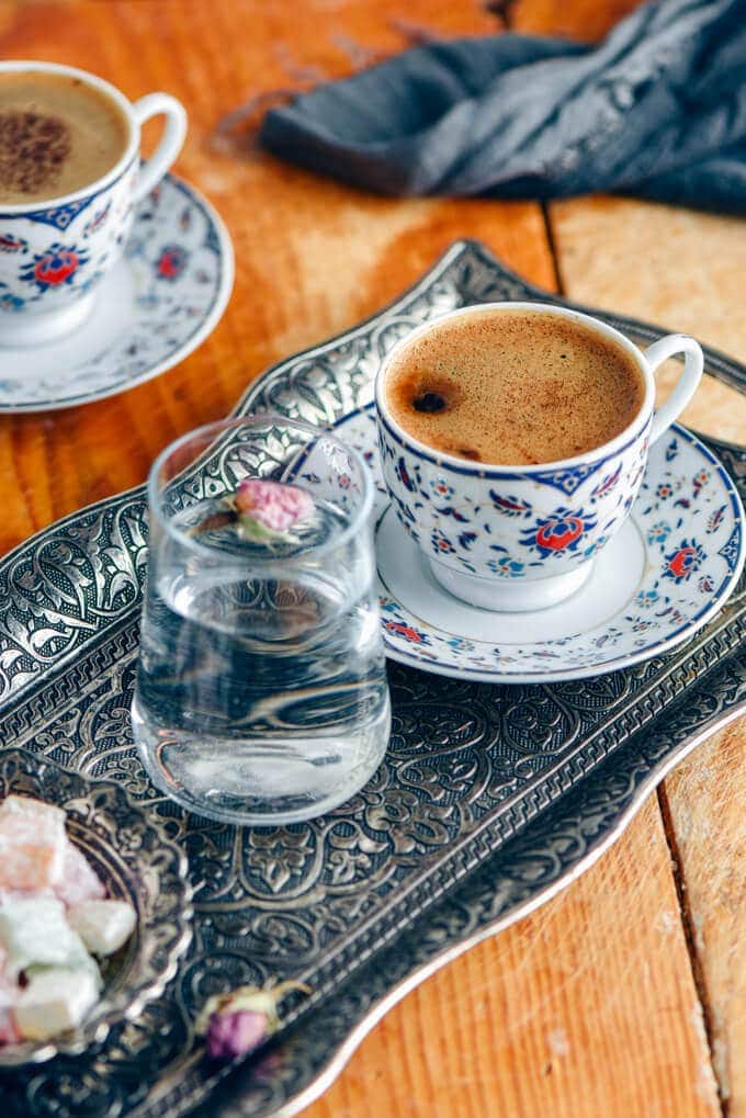 传统的土耳其咖啡盛在传统的铜托盘上，旁边放着一小杯水。