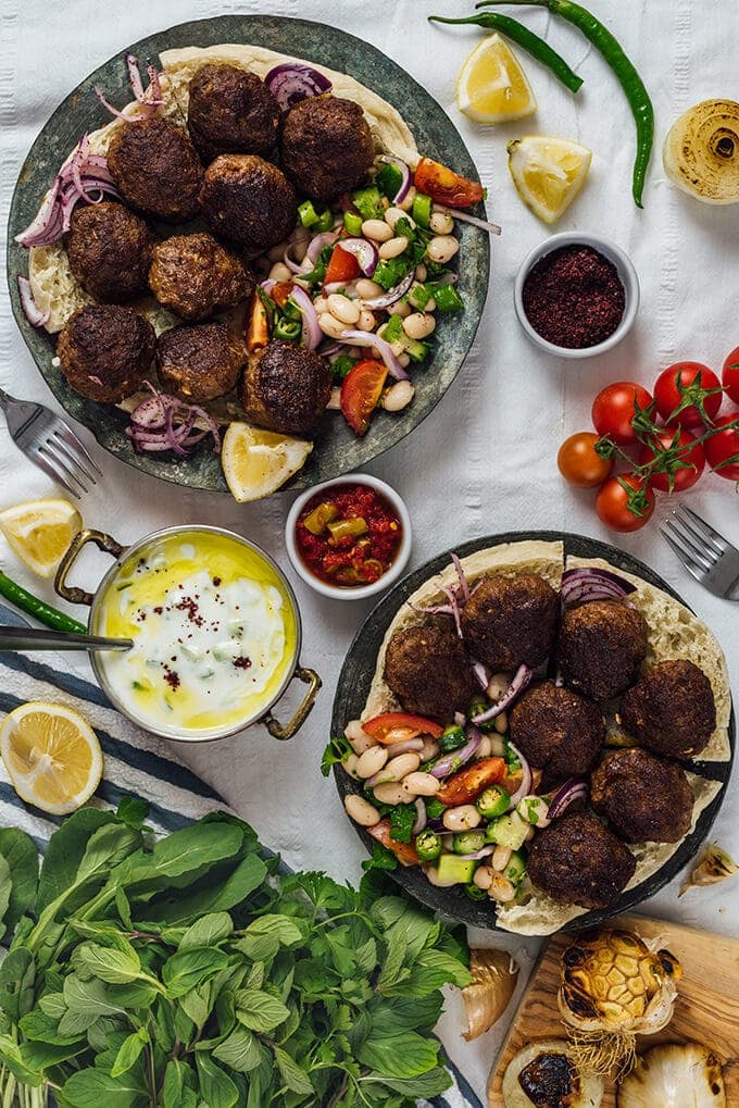 Homemade Turkish Meatballs are spicy, tender and perfectly juicy. It’s not a secret any more to make meatballs at home. #turkishfood #meatballs #meatballsrecipe #middleeasternfood #kofta #kofte 最好的土耳其肉丸装在铜盘上,配上豆类沙拉和黄瓜蘸酱