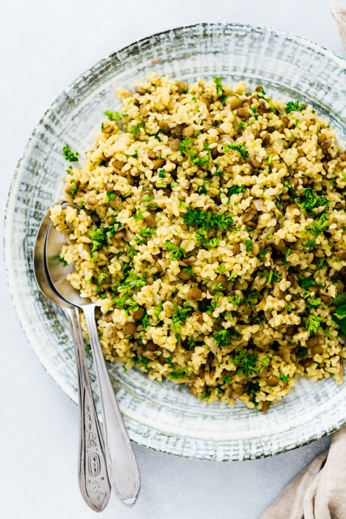 Bulgur pilaf with lentils and herbs make a super healthy and tasty side dish. #pilaf #bulgur #bulgurwheat #turkishfood #bulgurrecipe 用一个大瓷碗盛着绿扁豆和香草的保加利亚肉抓饭。