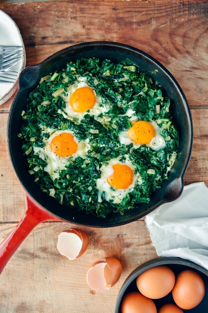 Fried Eggs with Spinach is an easy dish you can make in one pan. It is packed with great flavors and nutritious foods. Makes a delicious lunch or dinner that is ready in no time! #eggs #spinach #eggswithspinach 用铸铁锅盛菠菜蛋