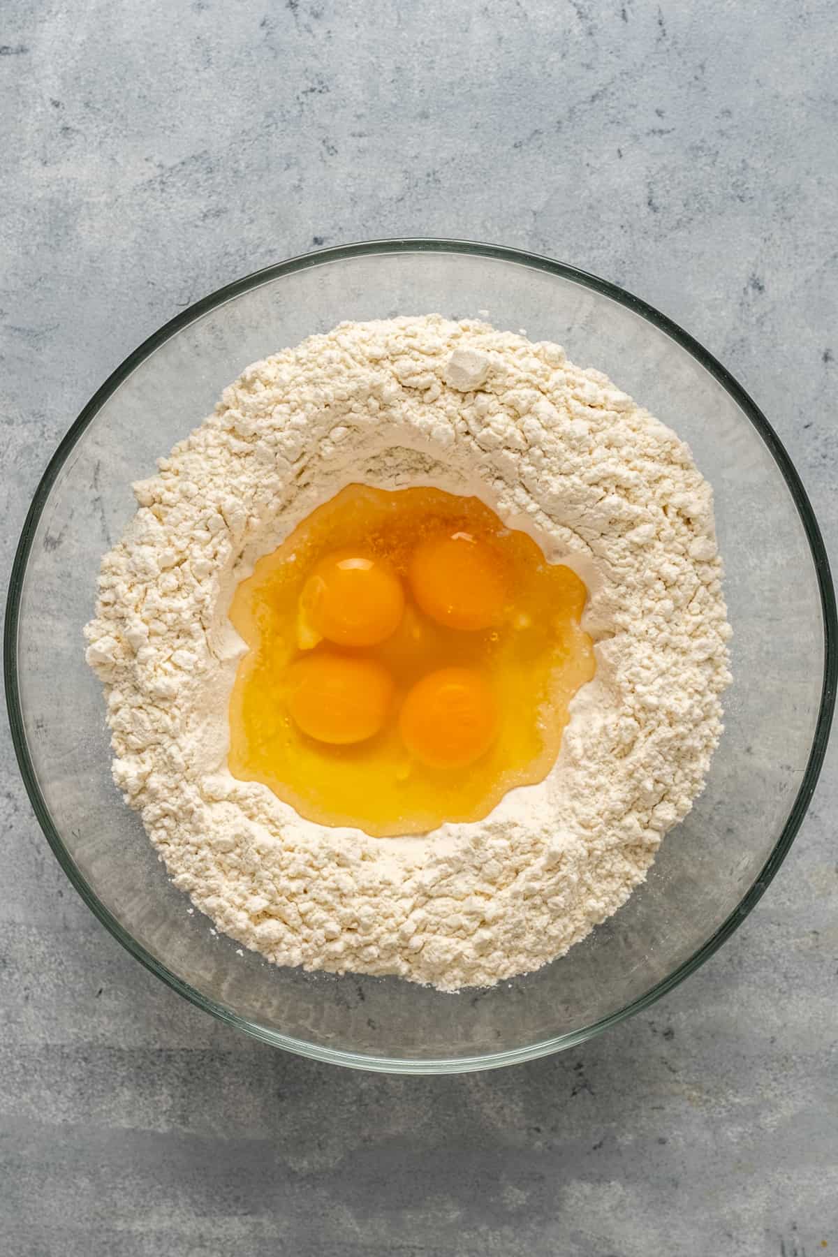 把面粉放在玻璃碗里，鸡蛋放在碗中间。