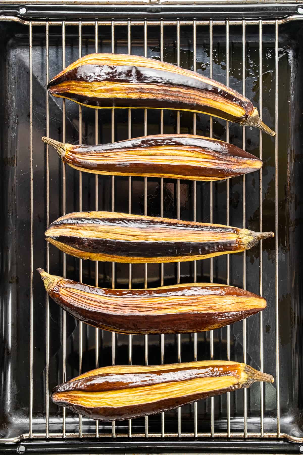 部分去皮的茄子放在烤架上烤。