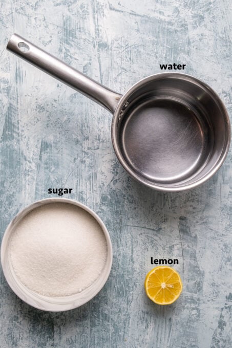 糖在一碗水在一平底锅半柠檬光背景。