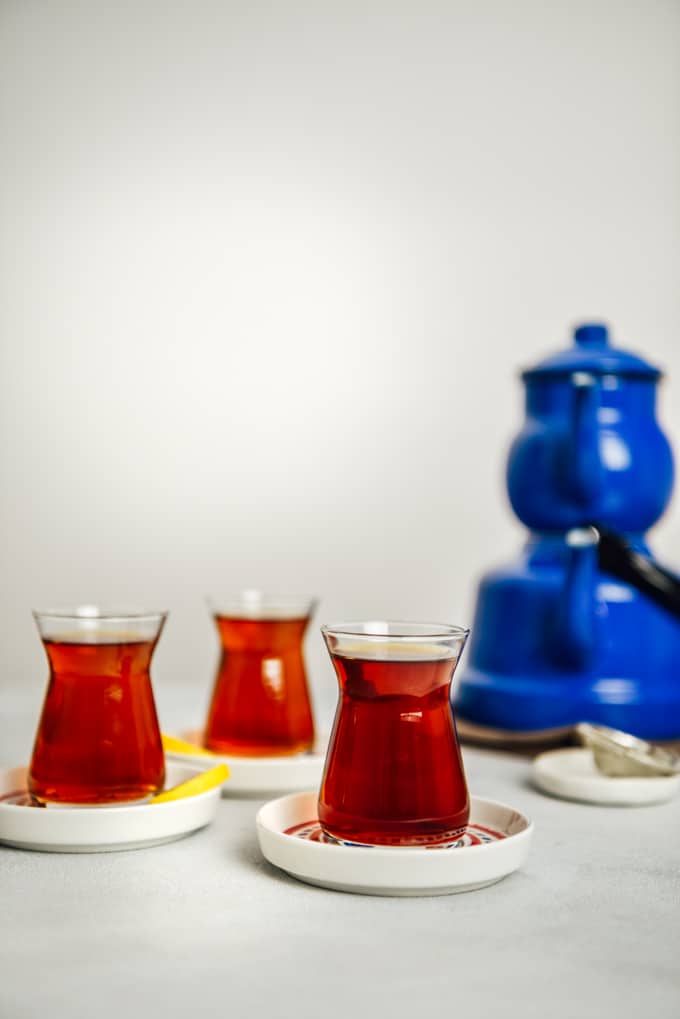 土耳其茶装在三个土耳其茶杯里，两个杯子边上放着薄薄的柠檬角。配有一套怀旧的蓝色茶壶。