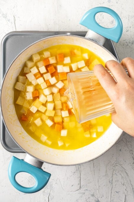 将橙汁倒在切好的块根芹、胡萝卜和榅桲上。