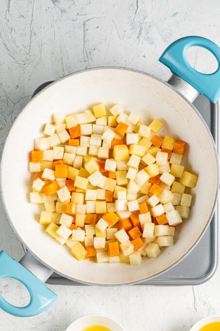 将芹菜根、榅桲和胡萝卜切成丁，放入白锅中。
