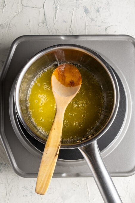 把融化的黄油放在酱锅里，里面放上木勺。