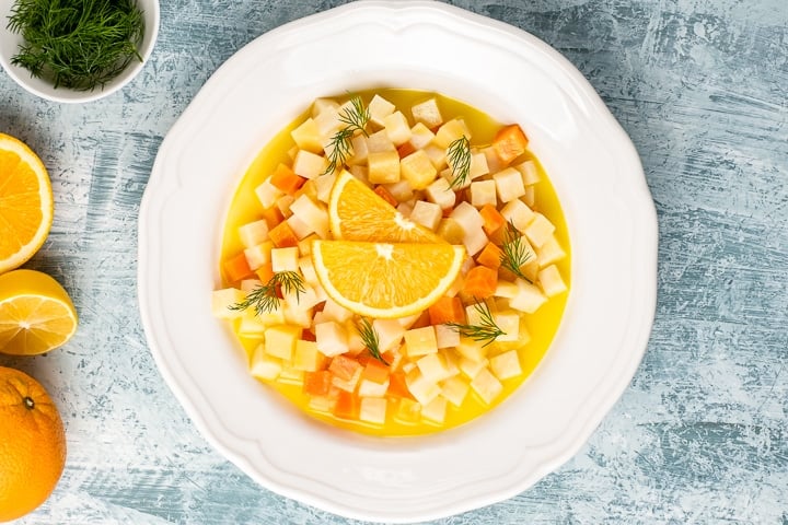 一种块根芹蔬菜，与胡萝卜、榅桲和柑橘口味的菜一起做成白色的盘子。
