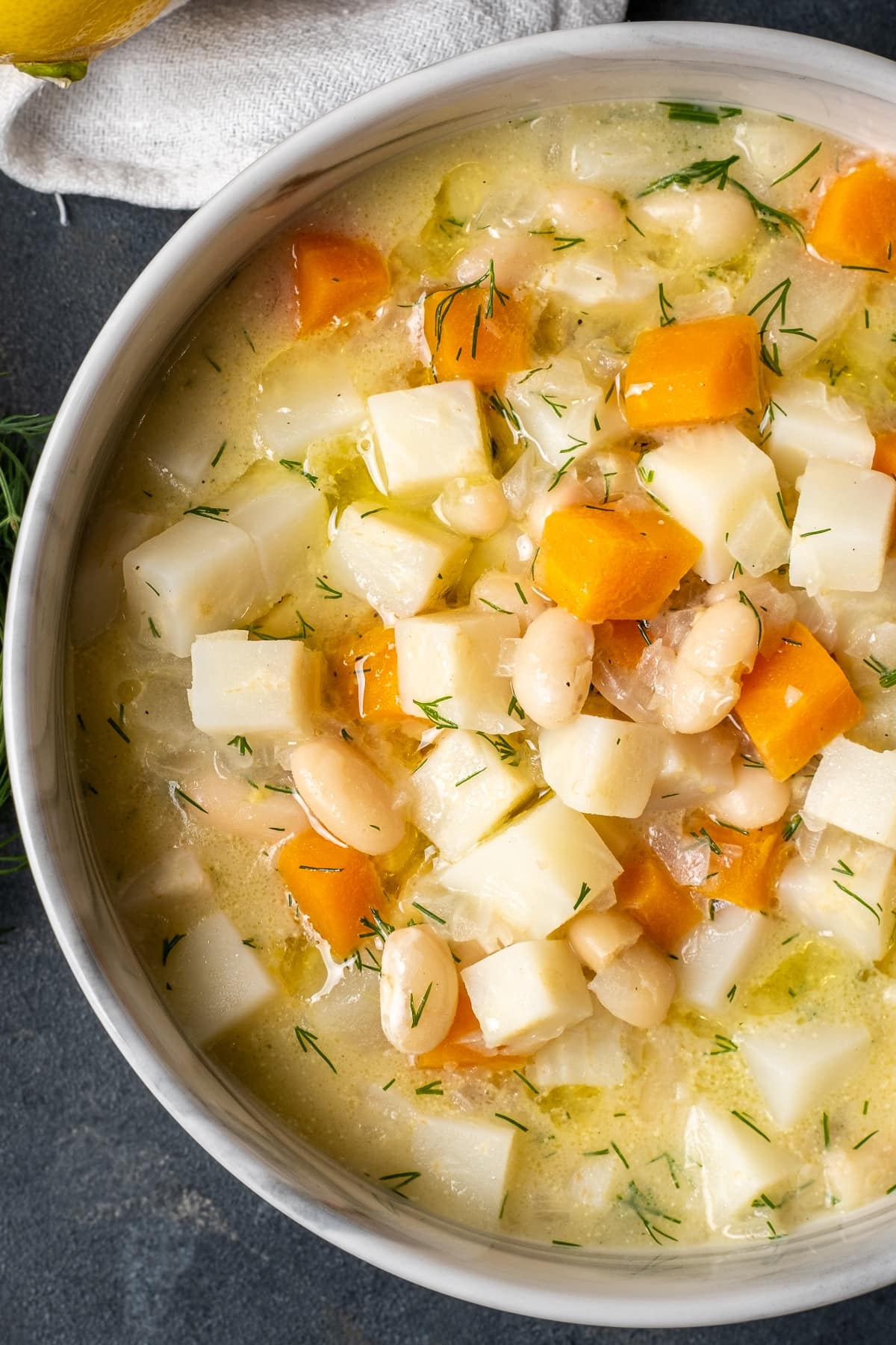 芹菜根汤用苹果，红萝卜和豆在一个碗在黑暗的背景。