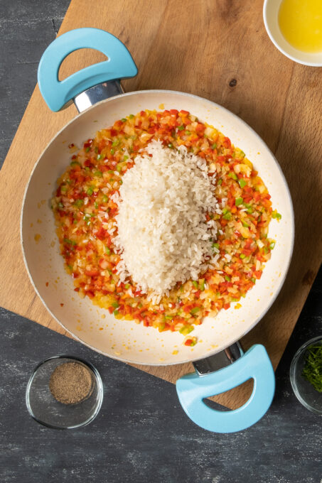米和蔬菜在一块白色平底锅。