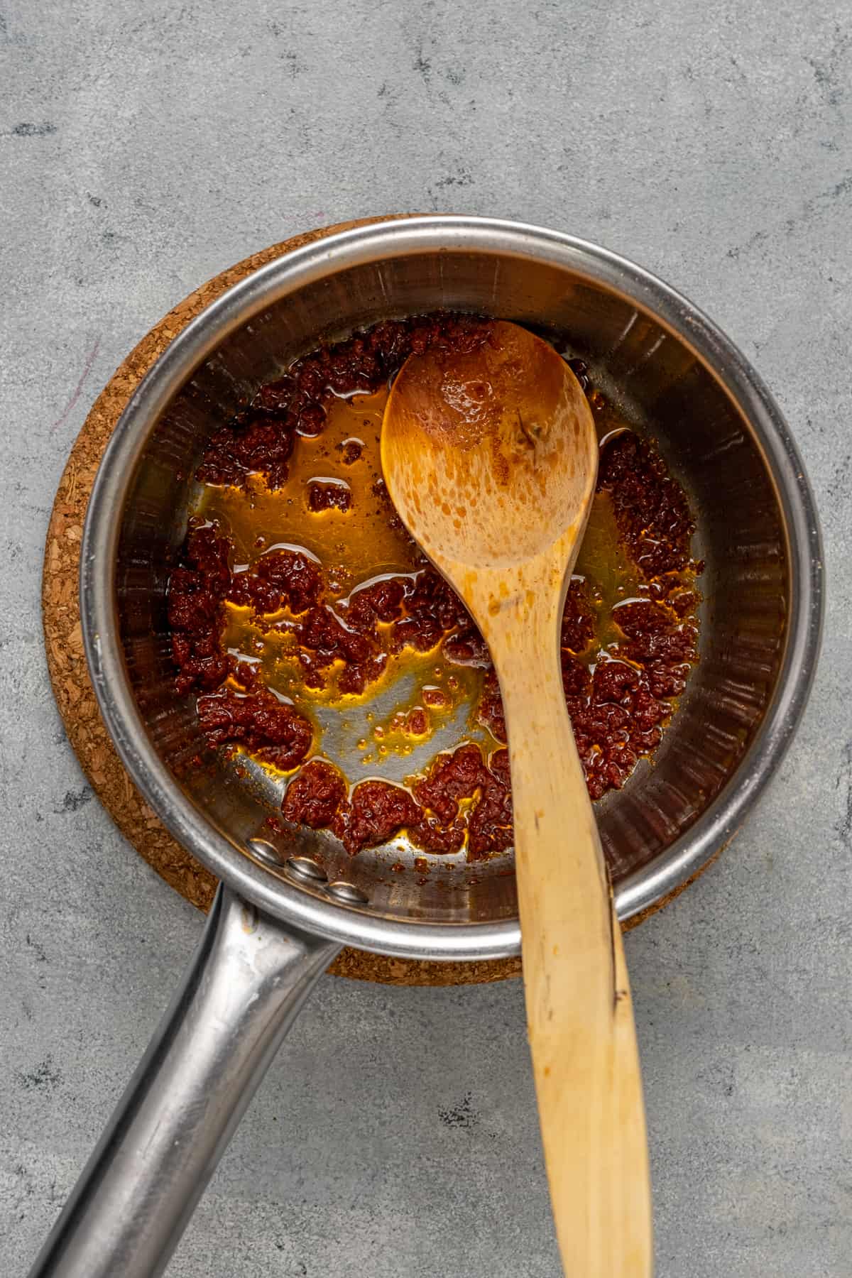 在一个小炖锅里放番茄酱，里面放一把木勺。