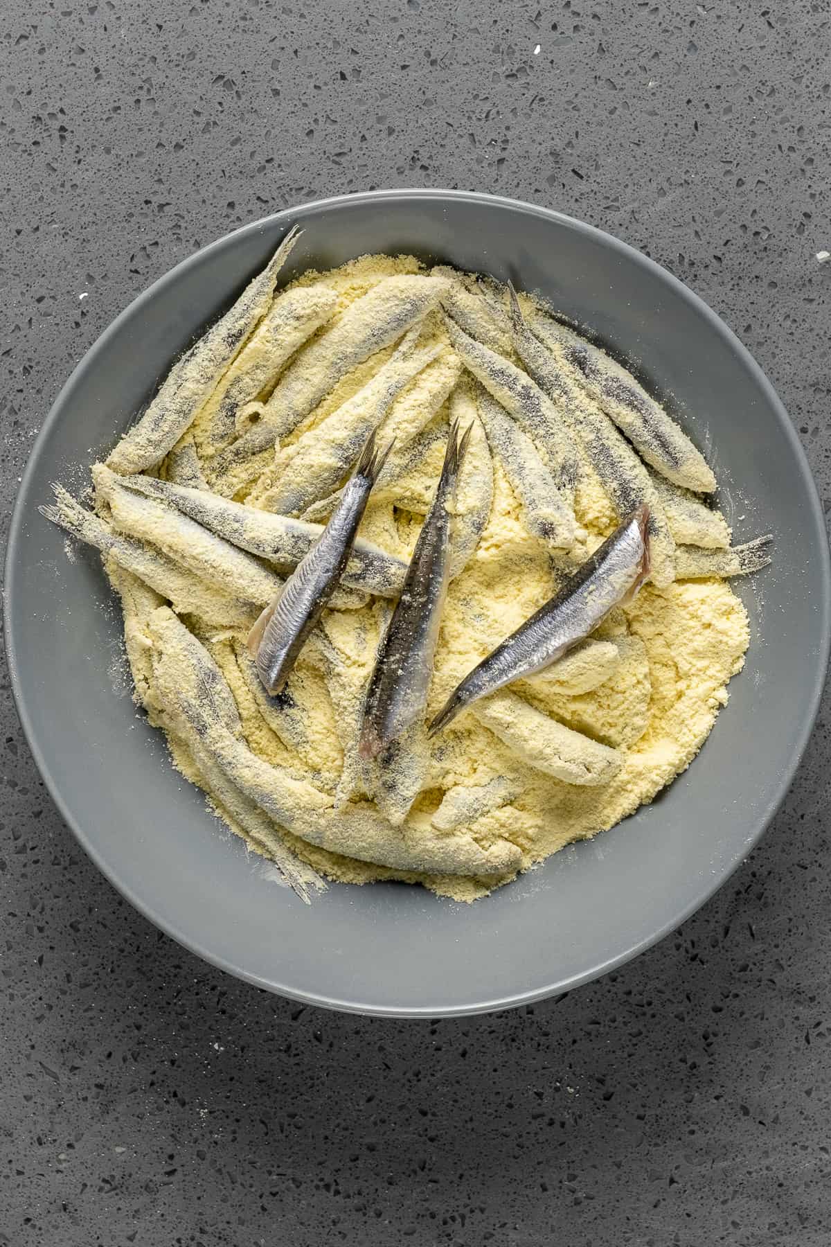 碗里裹着玉米粉的新鲜凤尾鱼。