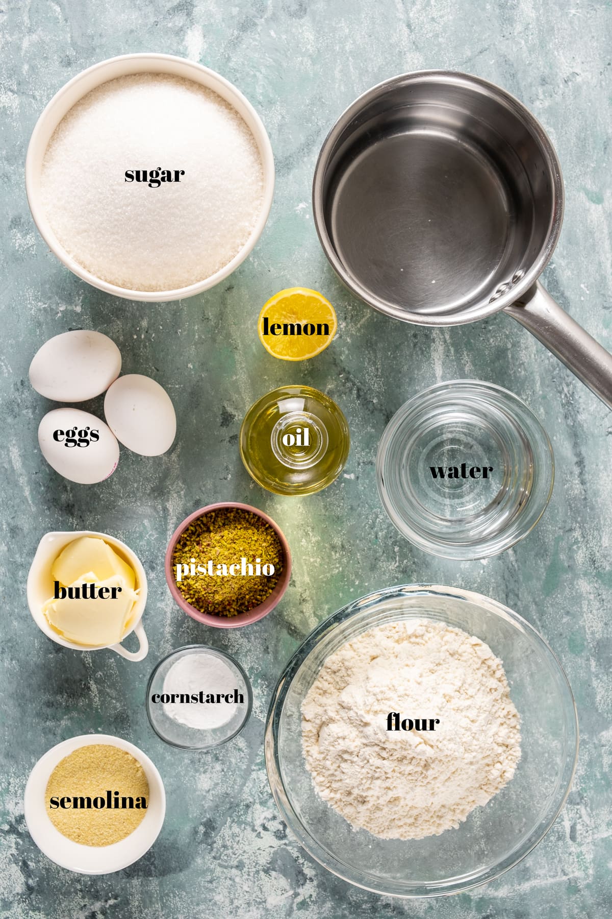 面粉，糖，小麦粉，鸡蛋，油，开心果，黄油，柠檬，玉米淀粉在浅色背景下拍摄。