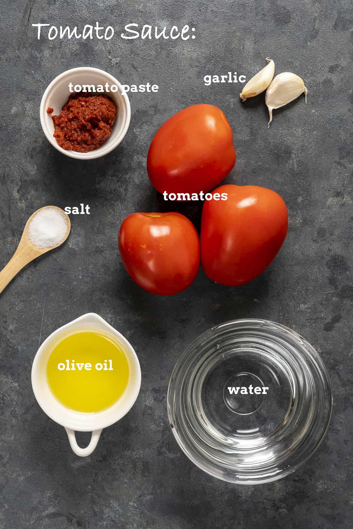 西红柿，番茄酱，大蒜，橄榄油，盐和水在黑暗的背景。
