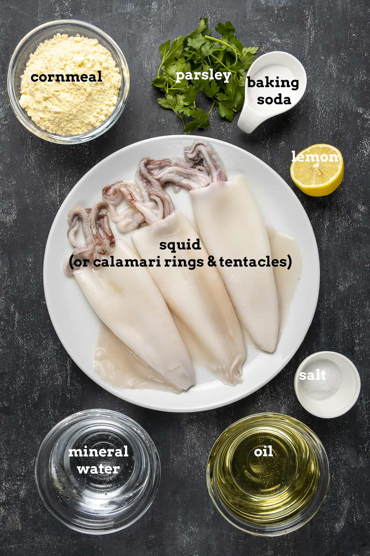 整个鱿鱼,玉米粉,欧芹,小苏打,柠檬,盐,油和矿泉水,黑色背景。