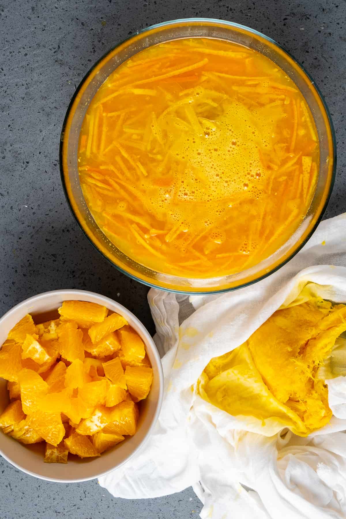 一个碗里放入切碎的橙子，另一个碗里放入橙汁和橙子皮切片。