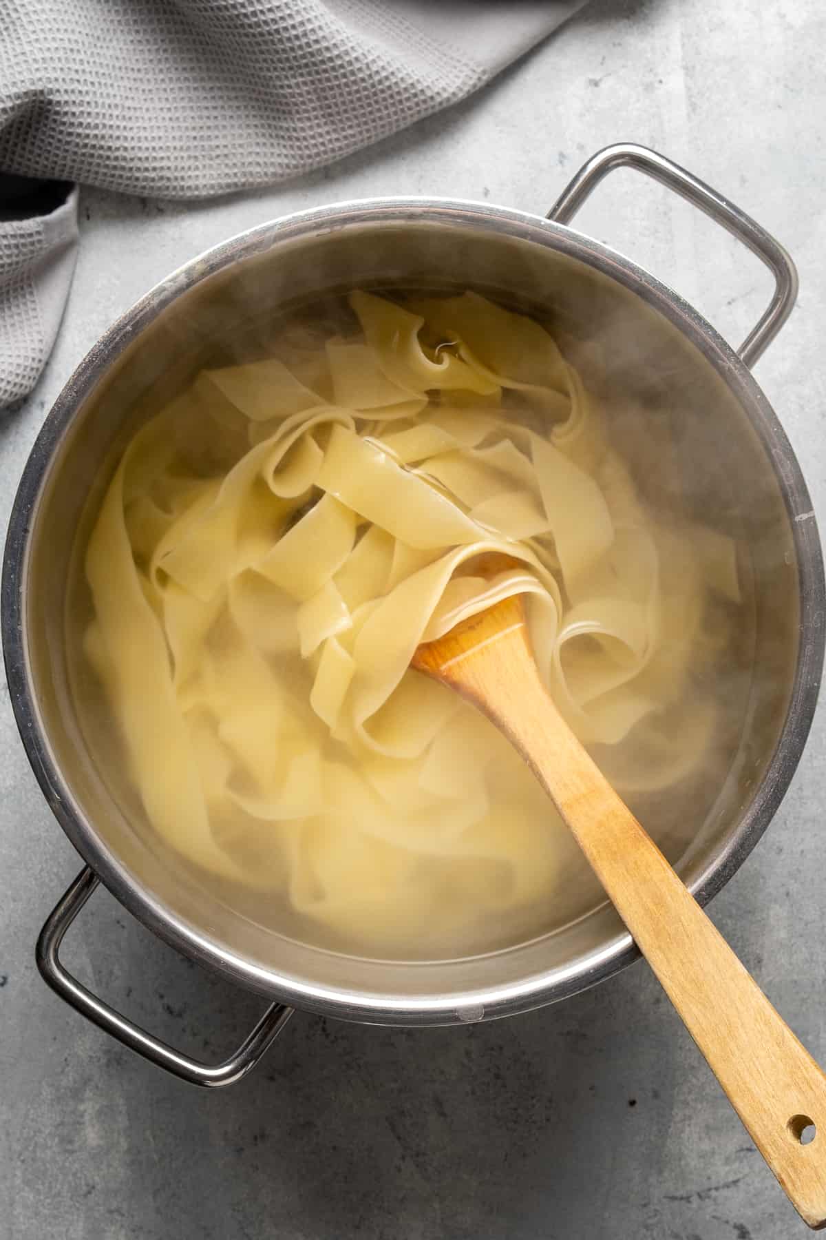 用木勺在锅里煮意大利面。