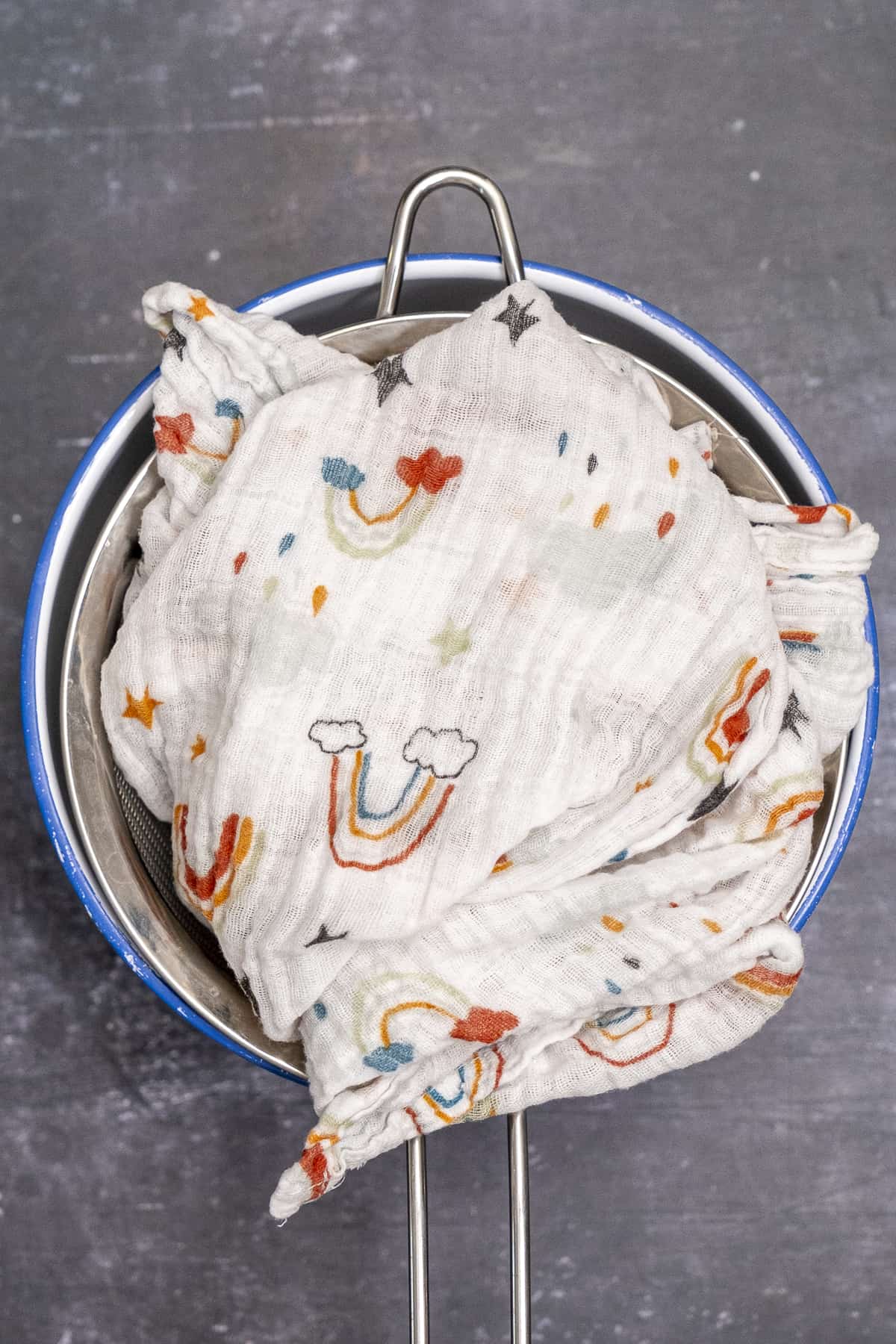 把细棉布折叠在酸奶上，放在一个大碗上的滤网里。