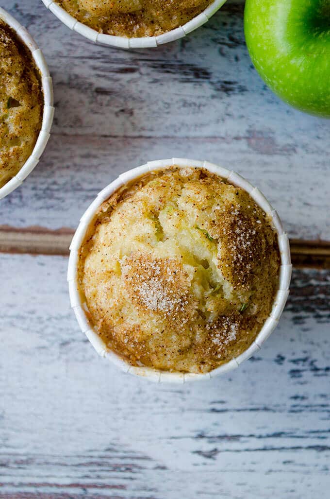 Zucchini Apple Cinnamon Muffins with cinnamon sugar topping. Wonderfully moist thanks to zucchini, applesauce, grated apple and yogurt. Perfect on the go breakfast in fall! #zucchinirecipes #applecinnamonmuffins #fallbaking #zucchinimuffins 白色背景上的西葫芦苹果肉桂松饼