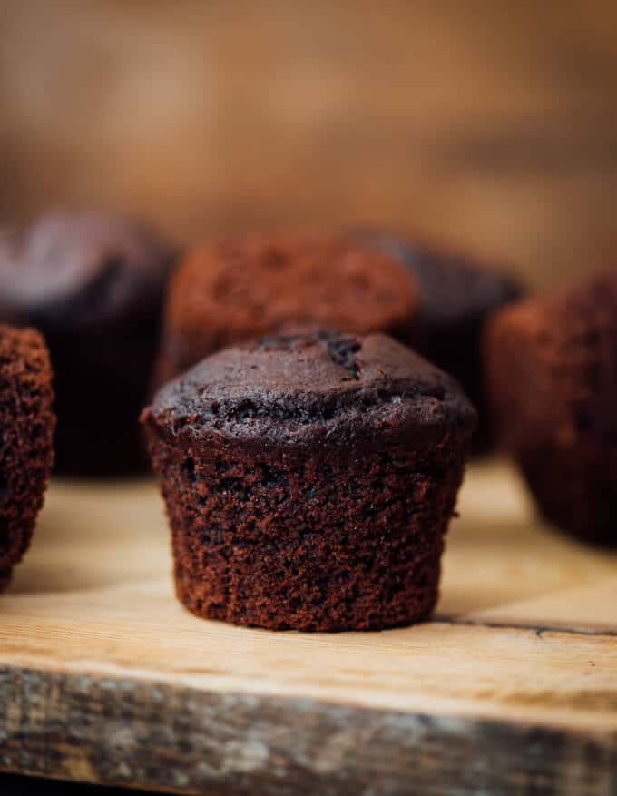 These Buttermilk Chocolate Muffins are perfectly moist, tender and chocolatey. You will feel like you’re eating brownies in each bite. These make a wonderful grab and go breakfast or a quick after school snack. #chocolatemuffins #muffinrecipe #buttermilkmuffins 白脱牛奶巧克力松饼在木板上
