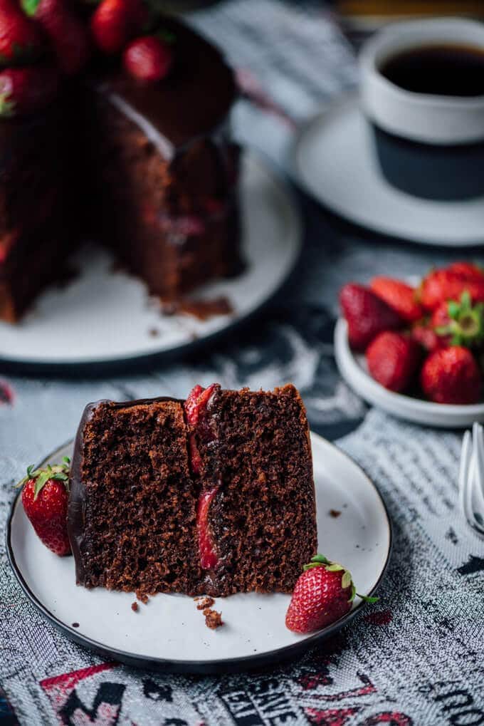 一片草莓巧克力蛋糕，装在盘子里。草莓和咖啡。