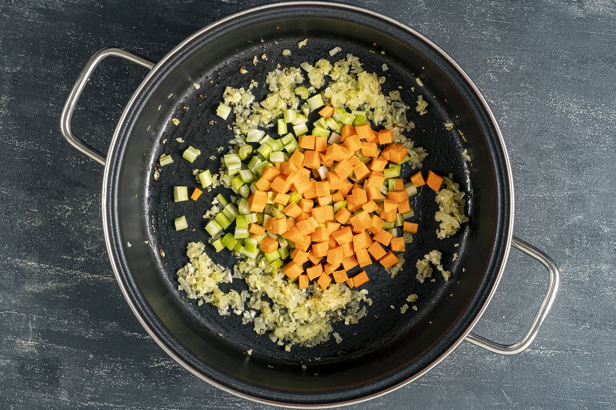 在锅里放入洋葱、胡萝卜和芹菜。
