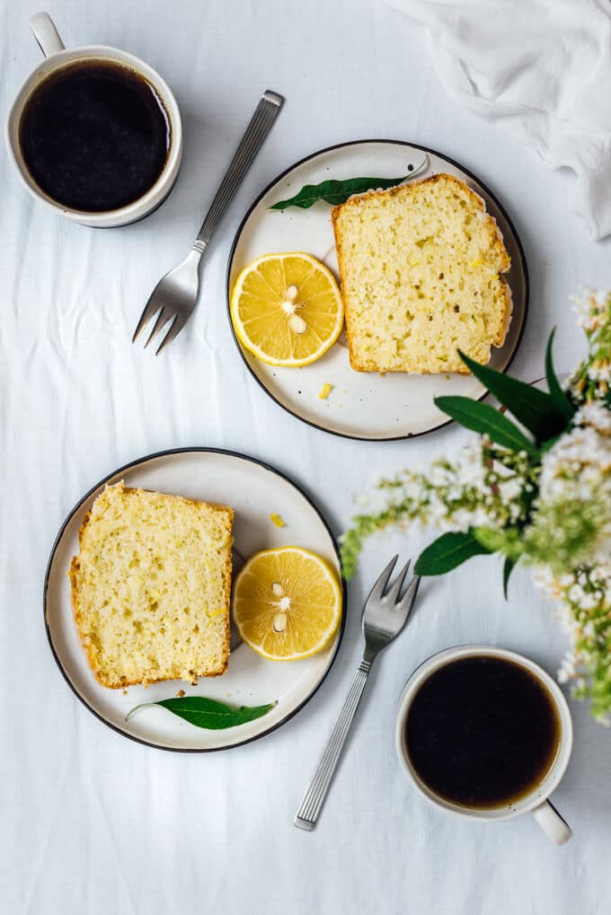 柠檬西葫芦蛋糕片放在两个盘子里，配上两杯咖啡。