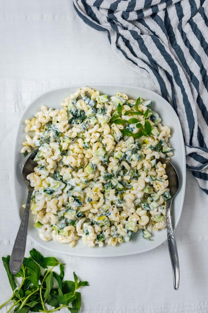 This Pasta Salad without Mayo is creamy and refreshing thanks to Greek yogurt and cucumber. Perfect summer lunch that is ready within minutes. #pastasalad #nomayo #yogurtpastasalad #pastarecipe 不加蛋黄酱的黄瓜意面沙拉,用勺子盛在白碗里
