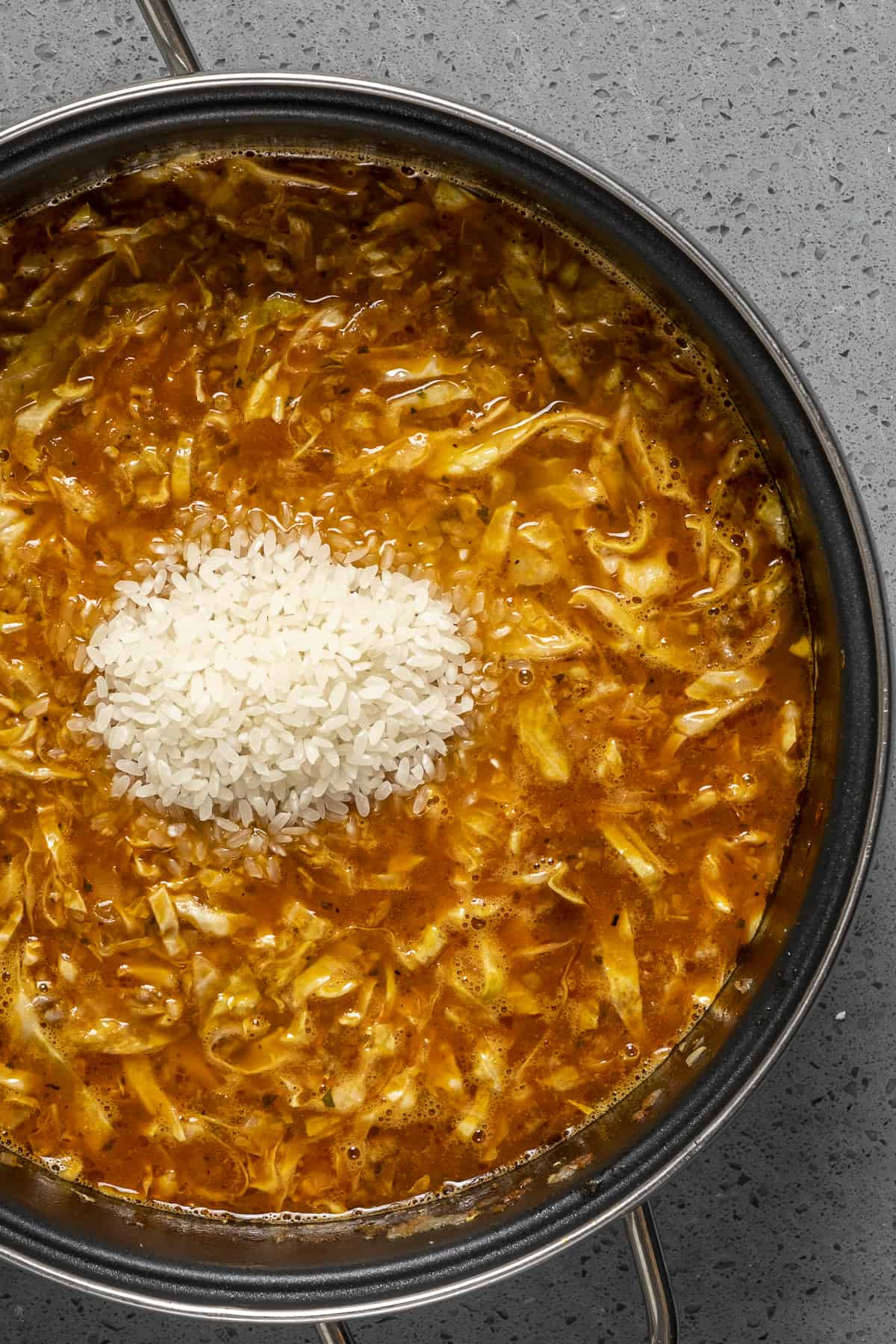 米饭被加到一锅卷心菜汤里。