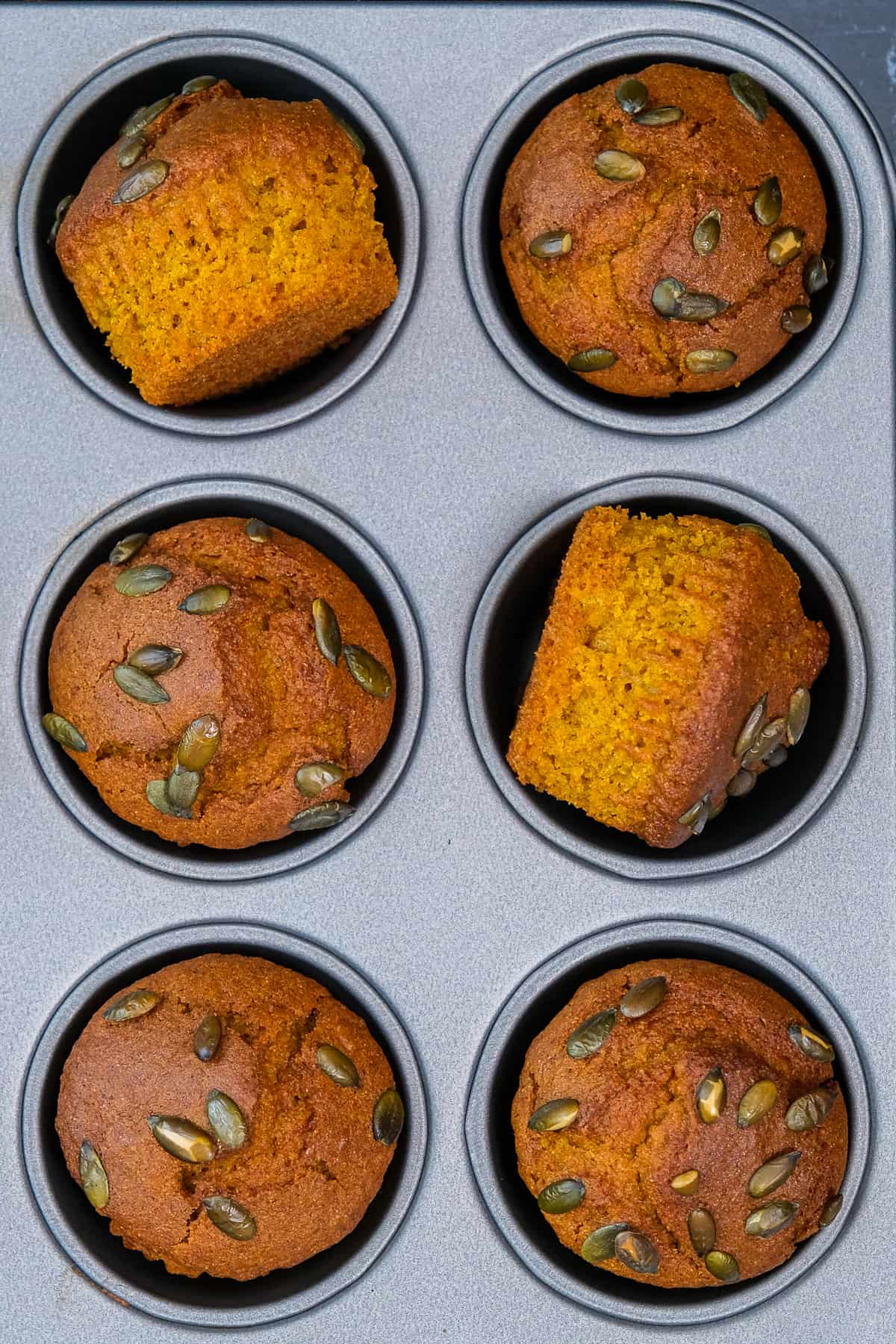 烤好的南瓜松饼放在灰色的松饼模里，上面撒上南瓜籽。