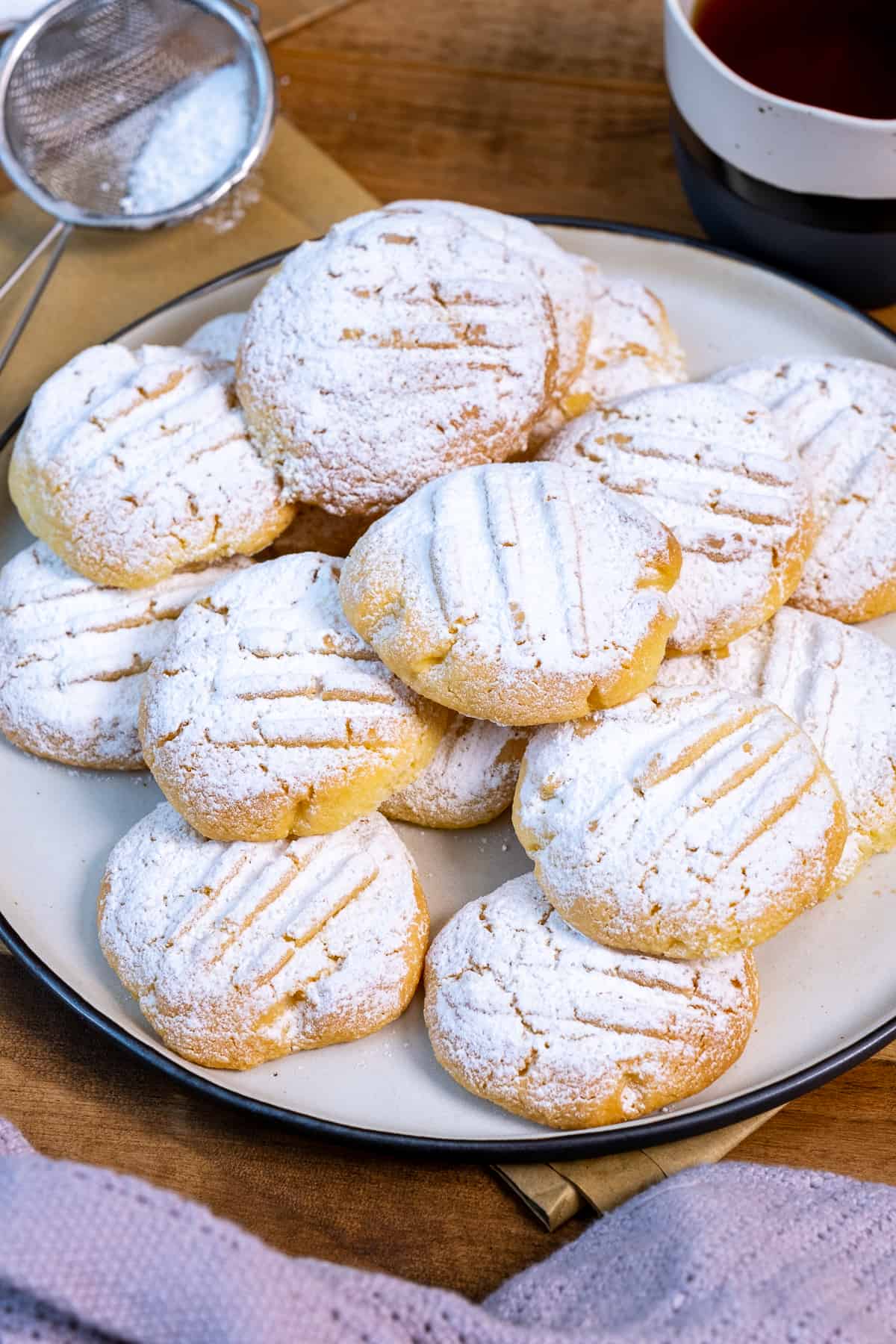 玉米淀粉饼干上面撒上糖粉，放在盘子里。