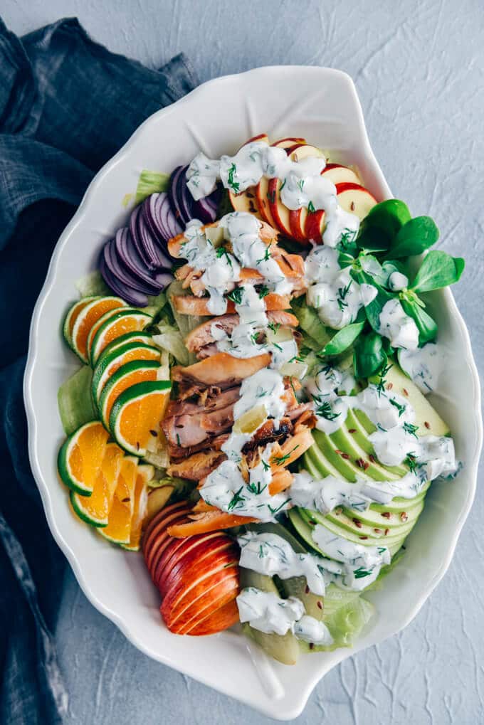 Chicken Salad with Apples is loaded with crisp apples, juicy oranges and red onions. The mouthwatering yogurt dressing with pickles makes this fall salad a big hit. #chickensalad #fallsalad #chickenapplesalad 鸡肉沙拉,苹果,生菜,马齿苋,橙片在一个白色的沙拉碗。