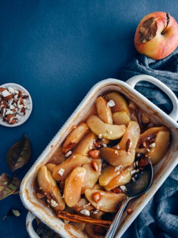 在烤盘里放入肉桂烤苹果片，配上苹果和杏仁。