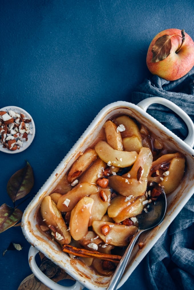 These cinnamon baked apple slices are like the gluten-free and vegan version of apple pie. Way easier to make! A perfect light dessert for fall. #applerecipe #falldessert #bakedappleslices 在烤盘里放入肉桂烤苹果片,配上苹果和杏仁。