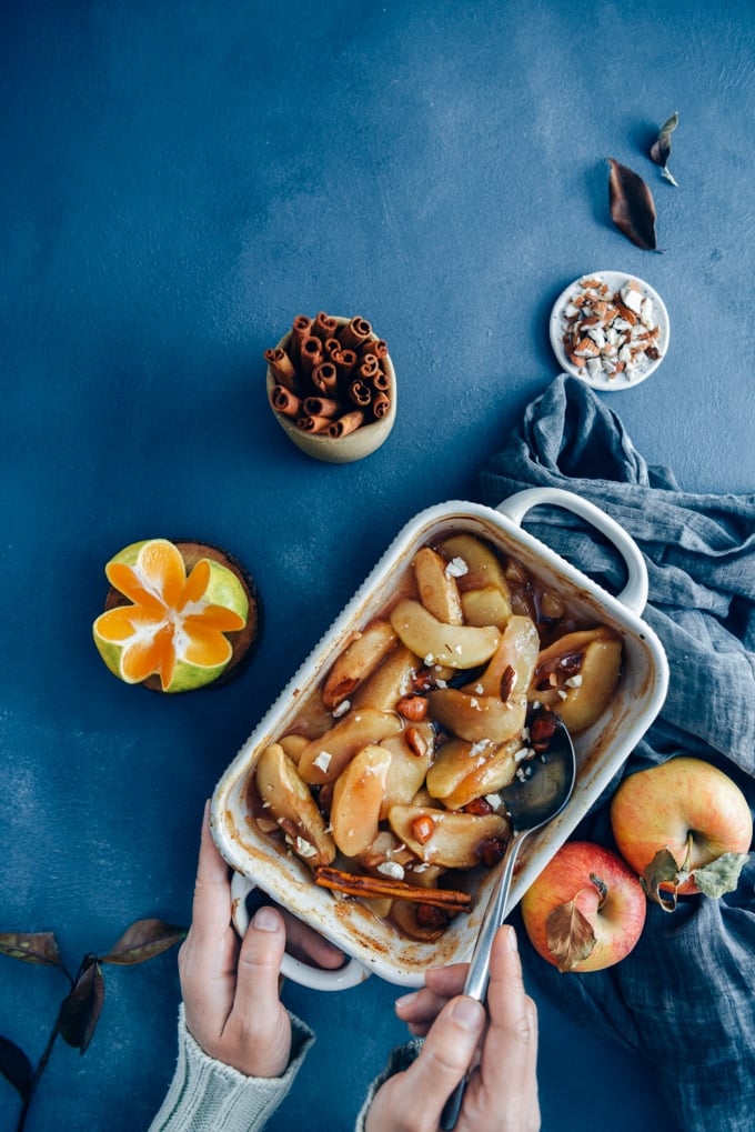 These cinnamon baked apple slices are like the gluten-free and vegan version of apple pie. Way easier to make! A perfect light dessert for fall. #applerecipe #falldessert #bakedappleslices 在烤盘里放入肉桂烤苹果片,同时放入苹果、肉桂棒、橘子和杏仁。