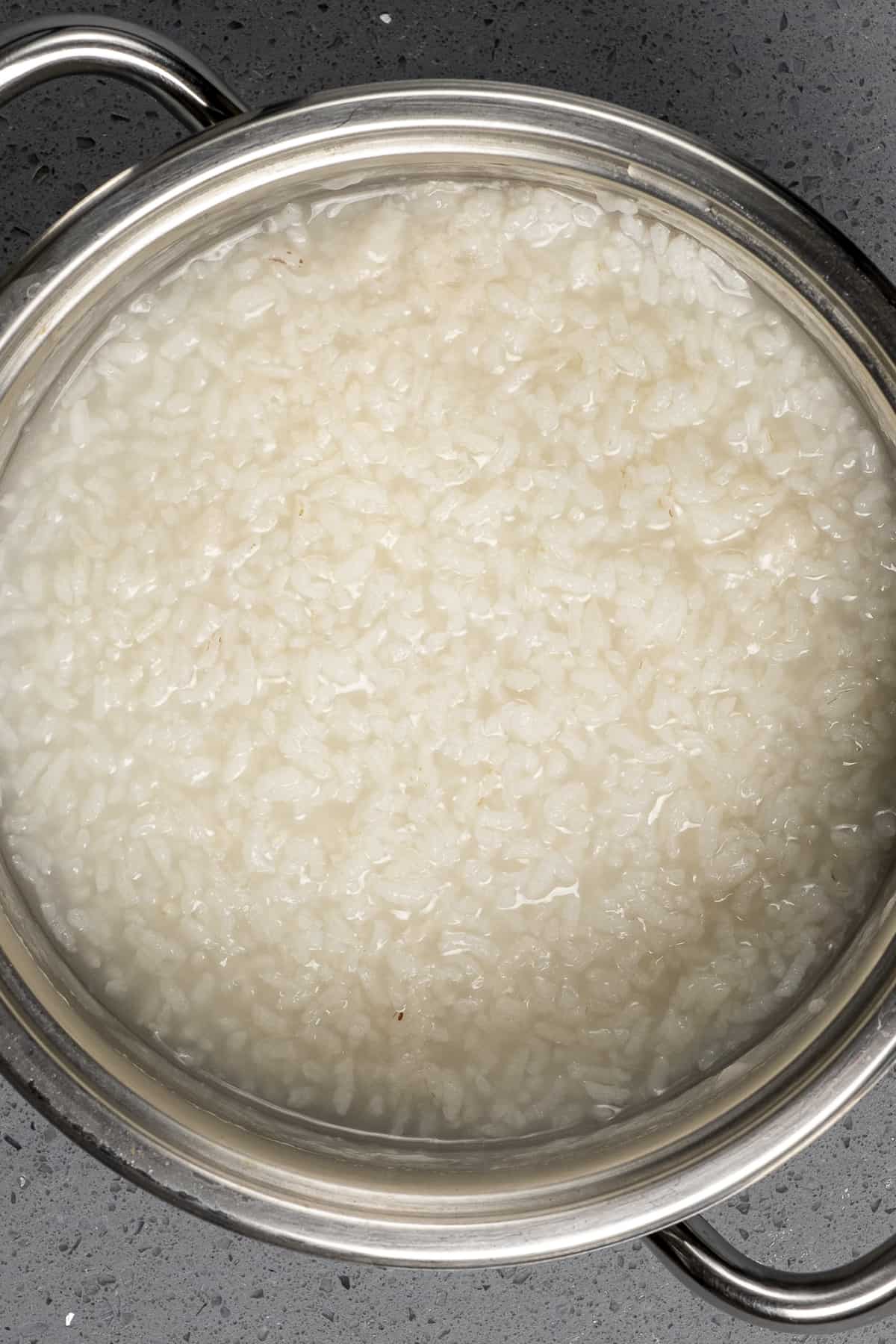 在平底锅里加入少许水，用奶油煮熟的米饭。