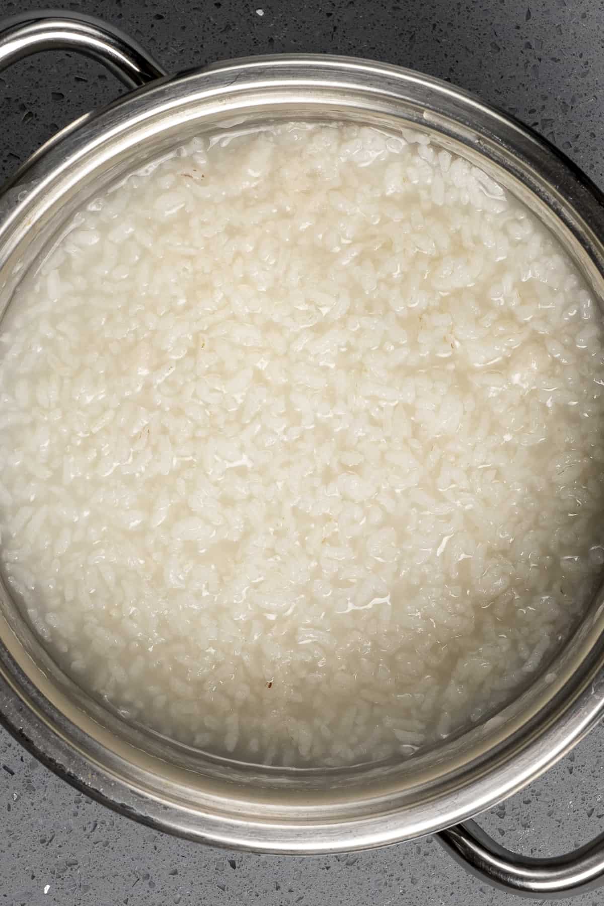 在平底锅里加入少许水,用奶油煮熟的米饭。