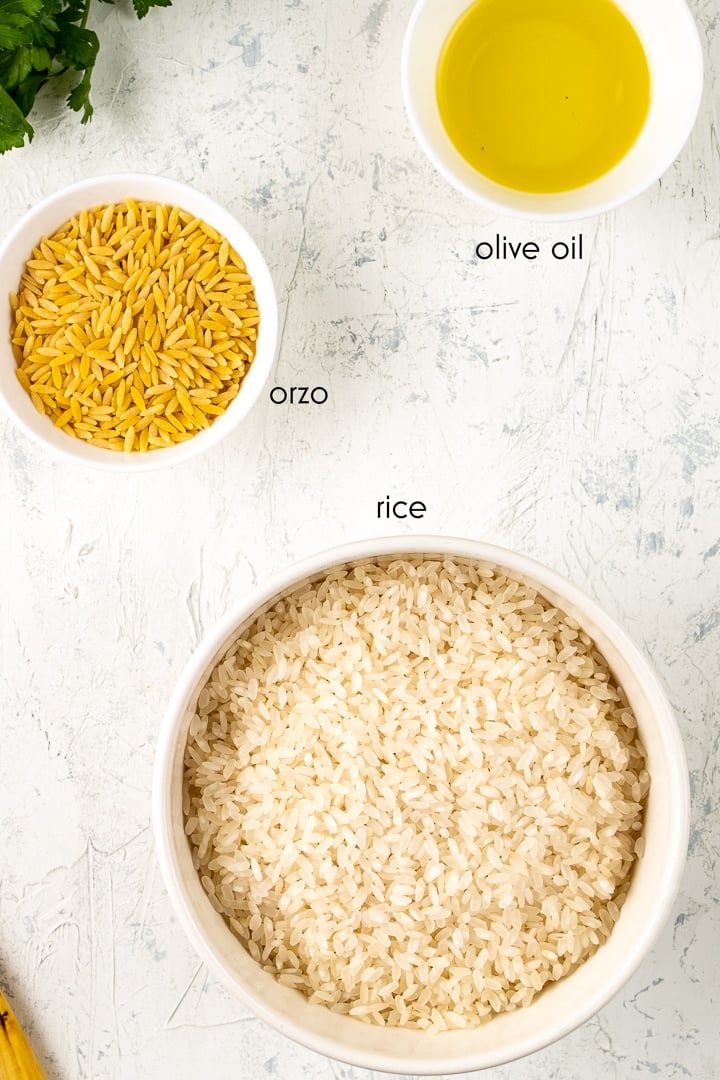 Orzo，米饭和橄榄油分别装在白色背景的碗里。