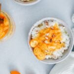 米粥的食谱，上面撒有肉桂、橘子酱、金桔和杏仁，盛在白色的陶瓷碗里。