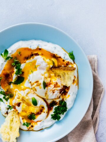 土耳其鸡蛋在一个蓝色的碗里淋上黄油酱。