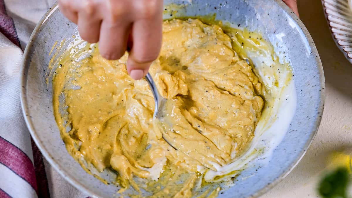 用叉子在碗里用手捣碎蛋黄和其他食材。