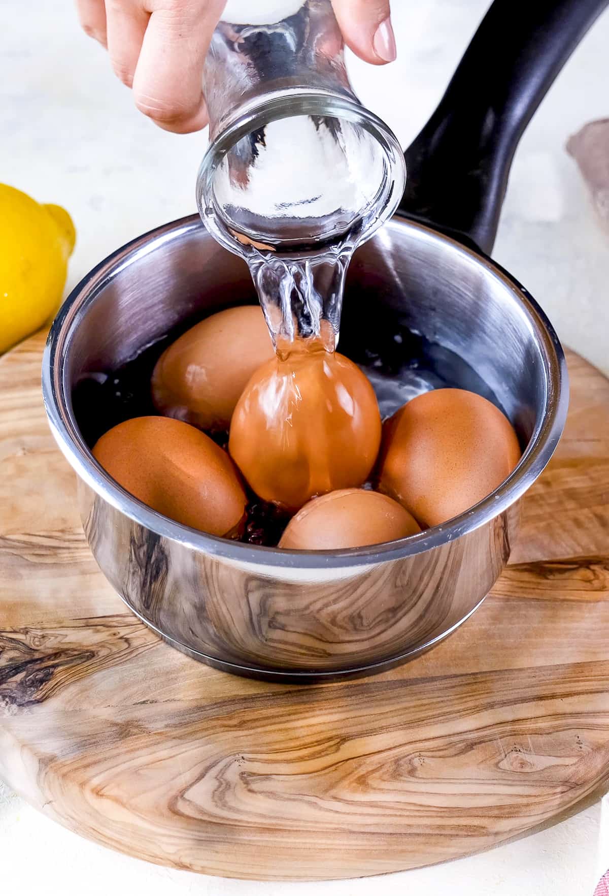 用手把水倒在平底锅里的鸡蛋上。