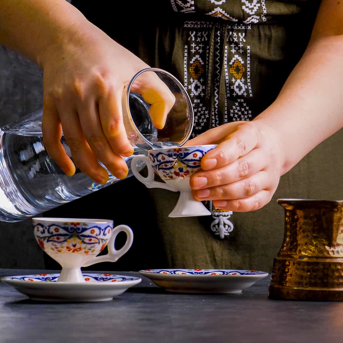 女人用土耳其咖啡杯量水