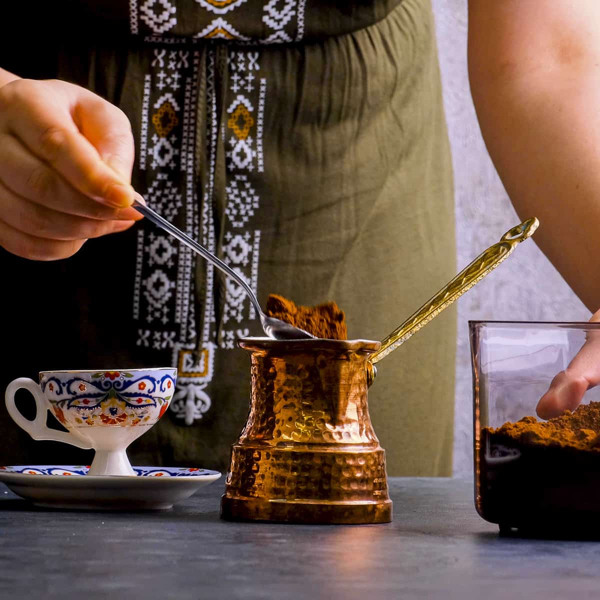 A woman preparing Turkish coffee in a traditional pot.