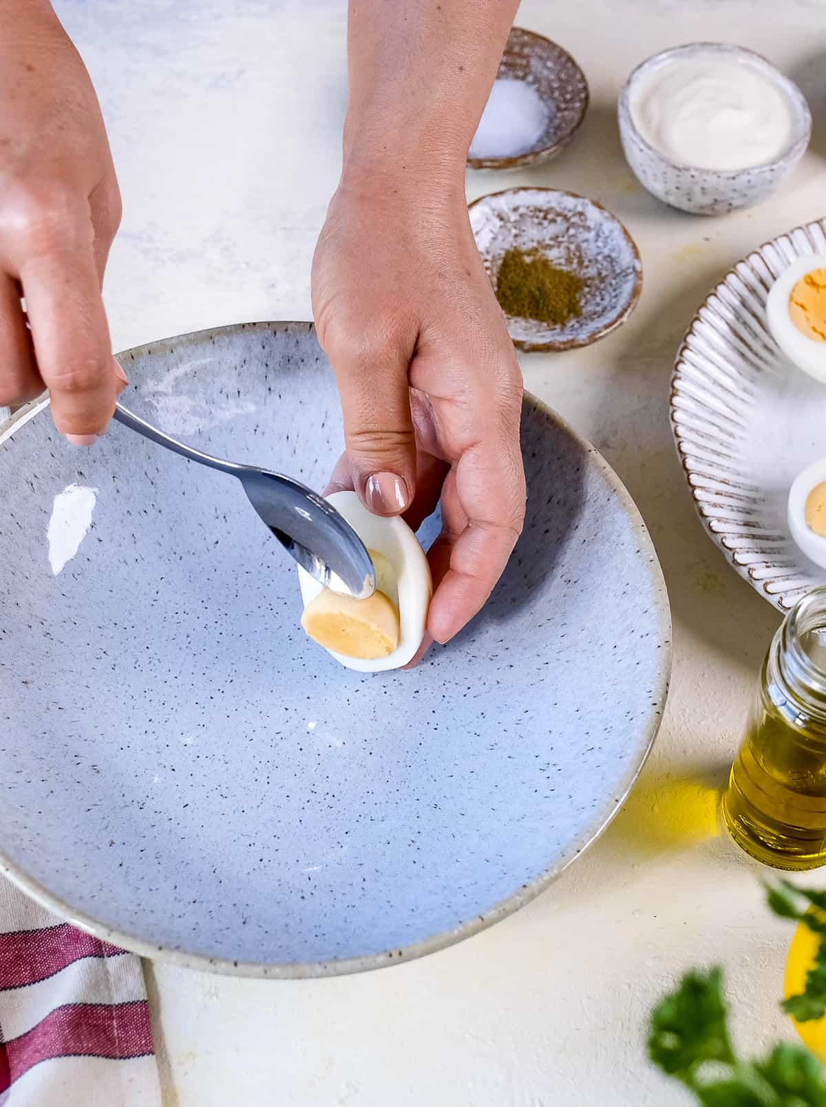 手用勺子从蛋白中取出煮熟的蛋黄。