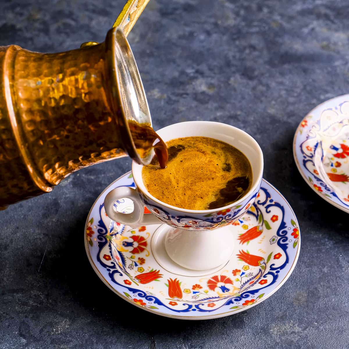 铜制土耳其咖啡壶将咖啡倒进传统杯子。