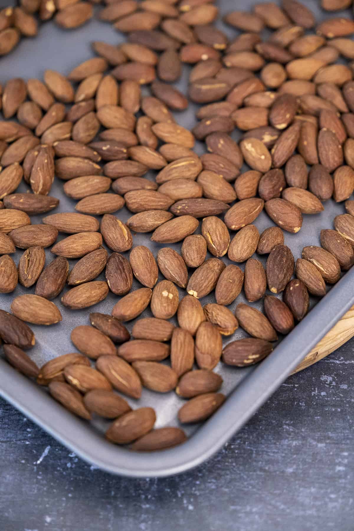 Roasted whole almonds on a baking sheet.